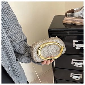Detail der Abendtasche mit funkelnden Strasssteinen und goldenem C-förmigem Griff