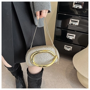 Detail der luxuriösen Strass-Abendtasche mit goldener Metallgriff und feiner Kette