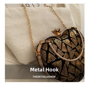 Detail of heart-shaped sequin evening bag featuring gold hardware and gemstone clasp