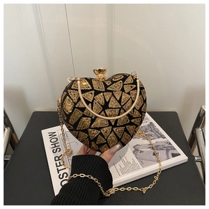 Detail of heart-shaped clutch with gold geometric sequins and a chain strap