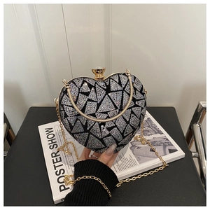 Detail of heart-shaped sequin evening bag featuring geometric patterns and gold metal frame