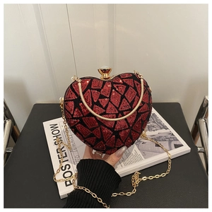 Macro view of heart-shaped evening bag with red and black sequins and gold chain strap