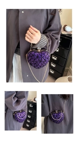 Macro shot of purple sequin heart-shaped evening bag with metal ring handle and rhinestone