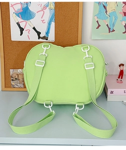 Detail view of mint green backpack straps and white plastic buckles with multi-hook system