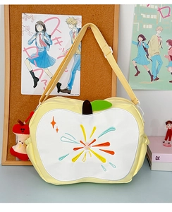 Macro shot of apple core shaped shoulder bag with star embroidery and plush pendant