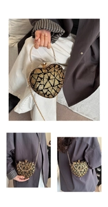 Detail of heart-shaped sequin evening bag with geometric gold patterns and metal handle