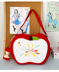 Detail of red apple-shaped canvas bag with embroidery and core-shaped plush charm