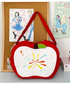 Detailed embroidery on a red apple-shaped canvas bag with adjustable shoulder strap