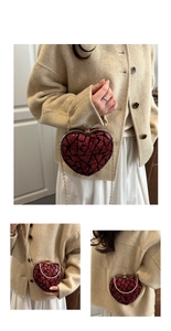 Close-up of heart-shaped evening bag with red sequins, gold frame and delicate chain strap