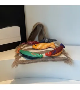 Artistic layout of five colorful fish-shaped knit fabric toys with diverse patterns