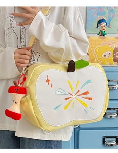 Detail of apple-shaped shoulder bag featuring sunburst embroidery and plush charm