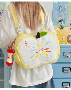 Detail of apple-shaped crossbody bag with colorful radial embroidery and plush charm