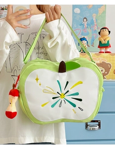 Detail of apple-shaped backpack with colorful sunburst embroidery and plush core charm