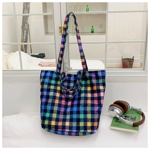 Detail of colorful plaid bucket bag showing thick woven fabric texture and rainbow grid design