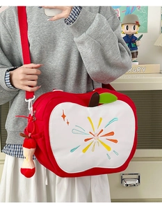 Detail of red apple backpack with colorful embroidery and mini apple core charm