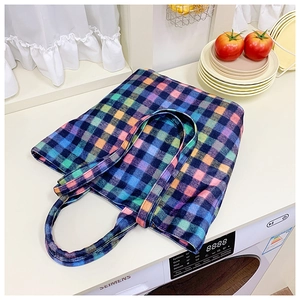 Close-up of colorful wool plaid bucket bag with thick textured checkered fabric