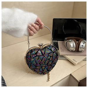 Macro shot of heart-shaped sequin evening bag featuring metal ring handle and crystal clasp