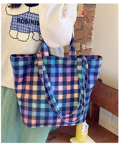 Detail view of colorful plaid canvas tote bag with thick texture and dual straps
