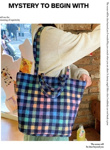 Colorful plaid woolen tote bag with dual straps shown in a stylish outdoor setting
