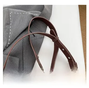 Close-up of adjustable leather shoulder strap with stitching on retro camera box bag