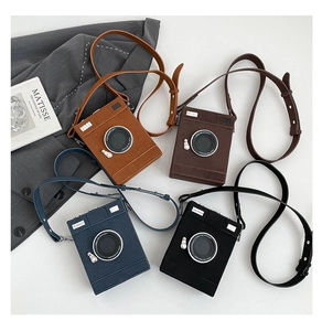 Flat lay of vintage camera shaped crossbody bags in four colors with Matisse art book