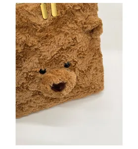 Detail der Teddybär-Plüschtasche mit goldenen Doppelreißverschlüssen und weicher Textur