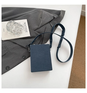 Detail of navy blue rectangle box bag with matte texture and silver hardware