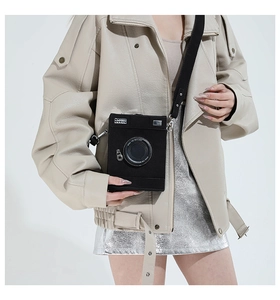 Detailed view of the creative camera shaped crossbody bag featuring a realistic lens and strap
