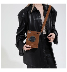 Brown vintage camera-shaped crossbody bag with 'Steal the Spotlight' lens detail