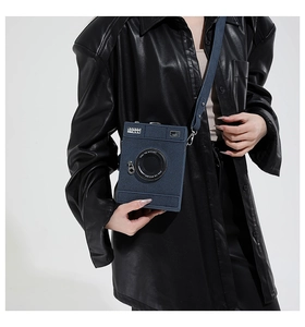 Detail view of a vintage camera-shaped crossbody bag with Steal The Spotlight text