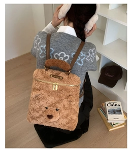 Detail eines süßen braunen Plüschbären Rucksacks mit goldenem Reißverschluss