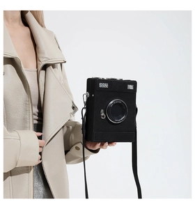 Macro detail of camera-shaped crossbody bag with realistic lens and matte finish