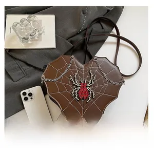Size comparison of heart-shaped spider web gothic crossbody bag with a smartphone