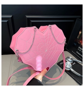 Detail der rosa herzförmigen Tasche mit silbernen Spinnweben-Nähten und Ketten