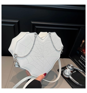 Detailansicht der weißen herzförmigen Tasche mit Spinnennetz-Steppung und Silberkette