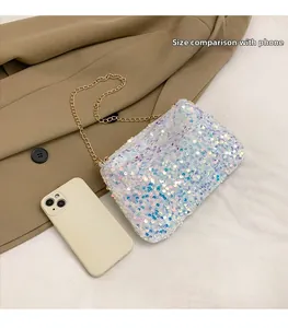 Detailed size comparison of a sequined mini crossbody bag next to a smartphone