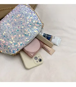Macro view of sequin crossbody bag interior showing spacious storage for makeup and phone