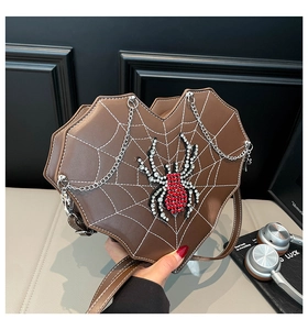 Detail der braunen Herztasche mit Spinnennetzmuster und glänzender Strass-Spinne Verzierung