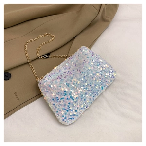 Detail of shimmering white sequins on a chain crossbody bag with golden hardware