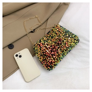 Detail of colorful sequins cross-body bag with gold chain strap on khaki coat
