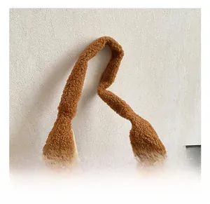 Détail du sac à main en peluche marron avec un nœud décoratif et une texture toute douce