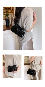 Detailed view of black sequined shoulder bag with gold chain strap and reflective texture