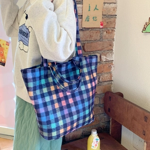 Women's plaid wool bucket bag with large capacity shown in a stylish outdoor setting