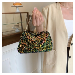 Macro detail of vibrant multi-color sequins and golden chain handle on a trendy square bag
