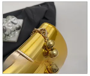 Detail showing high-shine gold magnetic clasp and beaded chain on an acrylic evening bag