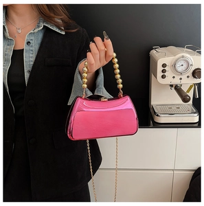 Chic pink metallic acrylic evening clutch bag featuring a bold gold bead handle and chain