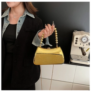 Detail of gold mirror acrylic box bag with beaded handle and fine chain strap