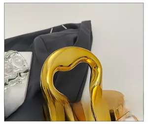Detail shot of the glossy gold handle on a vintage acrylic handbag for women