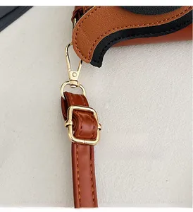 Close-up of golden metal buckle and premium stitching on the brown leather strap