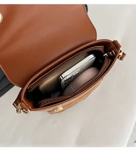 Interior view showing storage capacity of owl-shaped bag with phone and earbuds